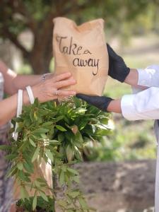 a bride and groom holding a paper bag with take a away at Agriturismo Villa Coluccia in Martano