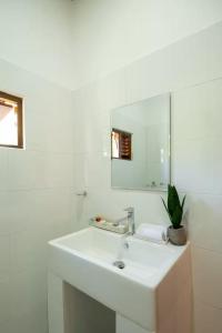 a white bathroom with a sink and a mirror at Villa Rivora Wadduwa in Wadduwa