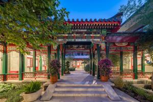 an entrance to a building with potted plants at Floral Hotel Beijing Heyuan Courtyard Luxury Hotel in Beijing