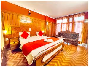 a bedroom with a large bed and a couch in it at Hotel Nainita Ankur ! Naini Lake View - On Terrace Open Restauarant with Lake View and Valley Mountain View with Wifi - Room Service Available - Best Vacation Stay with Family - Book Now in Nainital