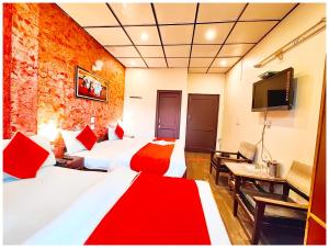 a hotel room with two beds and a television at Hotel Nainita Ankur ! Naini Lake View - On Terrace Open Restauarant with Lake View and Valley Mountain View with Wifi - Room Service Available - Best Vacation Stay with Family - Book Now in Nainital +23 photos