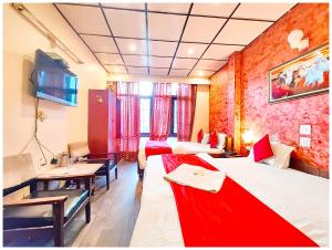 a hotel room with two beds and a table and chairs at Hotel Nainita Ankur ! Naini Lake View - On Terrace Open Restauarant with Lake View and Valley Mountain View with Wifi - Room Service Available - Best Vacation Stay with Family - Book Now in Nainital