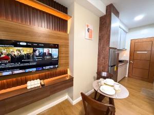 a dining room with a table and a tv in a room at Mellow Vibes City View in Davao City