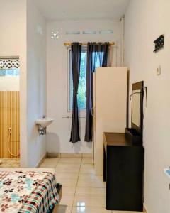 a room with a bed and a dresser and a sink at Alvaro Resort Bukit Angin in Ciguntur +9 photos