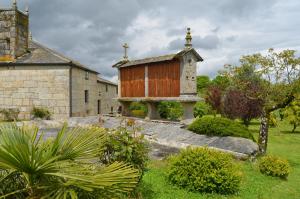 a small church with a cross on top of it at Casa de Martiño in Friol