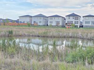 a row of houses next to a body of water at Stormwater Haven in Winnipeg