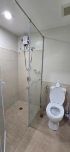 a bathroom with a toilet and a glass shower at Persimmon Studios Mabolo Cebu City in Mabolo