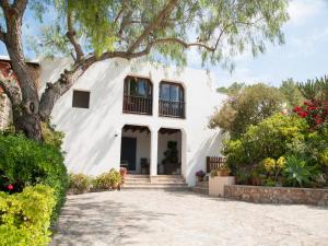 a white house with a tree in front of it at Stylish Ibiza Villa with Pool in Ses Paisses