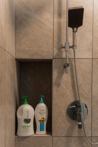 two bottles of laundry detergent sitting in a shower stall at SpaciousFun4BR Home 9Pax 3Bath Snooker ALMA in Bukit Mertajam +43 photos