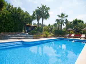 a swimming pool in a yard with palm trees at Stylish Ibiza Villa with Pool in Ses Paisses