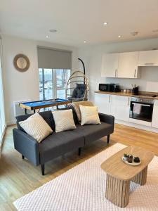 a living room with a couch and a ping pong table at City Condo-Terrace-Gym-Games Room -Free Secure Parking- Manchester in Manchester