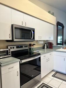 a kitchen with white cabinets and a microwave at Stoneybrook Condo #926 in Sarasota