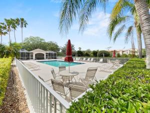 a pool with chairs and a table and a umbrella at Stoneybrook Condo #926 in Sarasota