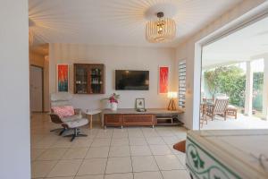 TV a/nebo společenská místnost v ubytování Villa La Papaye Jaune 3 ch, tous commerces accessibles à pieds