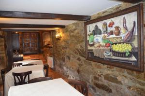 a dining room with a painting on the wall at Casa de Martiño in Friol