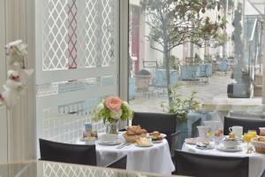 einen Tisch mit Essen und Blumen darauf in einem Restaurant in der Unterkunft Hotel Suites Unic Renoir Saint-Germain in Paris