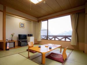 a living room with a table and a large window at Takato Sakura Hotel in Ina +28 photos