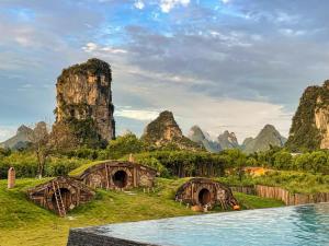 a resort with a pool in front of some mountains at 桂林阳朔良宿 LS Hotel Liangsu Yangshuo in Gaotian