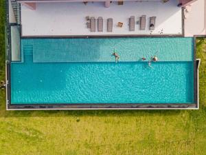 an overhead view of three people in a swimming pool at 桂林阳朔良宿 LS Hotel Liangsu Yangshuo in Gaotian