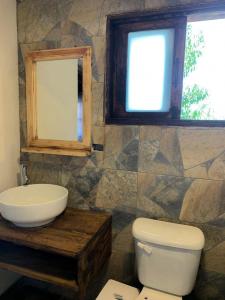 a bathroom with a sink and a toilet and a window at La Herencia de los Abuelos in Zacatlán