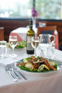 a plate of food on a table with a bottle of wine at Hotel Villa Adriana in Monterosso al Mare