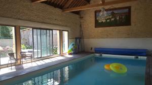 a swimming pool with a yellow ball in the middle at La Fresnée chambres d'hôtes in Mosles