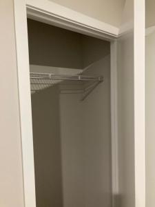a closet with a glass door with a metal shelf at 408B Jervois Street Mayfair in Hastings