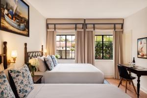 a hotel room with two beds and a desk at The Milo in Santa Barbara