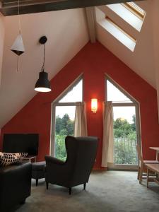 ein Wohnzimmer mit roten Wänden und einem Stuhl in der Unterkunft Casa Manderscheid in Manderscheid