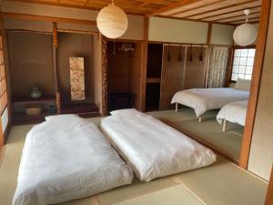 a room with two large white beds in it at MYOJI HOUSE 2 Traditional Japanese Stay in Katsuragi