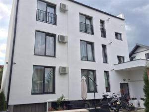 a white building with black windows at Hermann Apartments in Sibiu