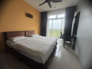 Un dormitorio con una cama con ventilador de techo y una ventana. en Executive Apartment at Cinta Sayang Club, en Sungai Petani