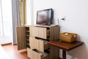 ein Wohnzimmer mit einem TV, einem Tisch und einem sidx sidx in der Unterkunft Big Church Homestay in Hanoi
