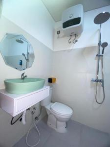 a bathroom with a sink and a toilet and a mirror at Villa Bulan by MentariPro Bali in Singaraja +5 photos