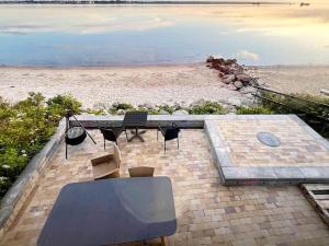 a table and chairs on the beach with the ocean at 4 person holiday home in Middelfart-By Traum in Middelfart