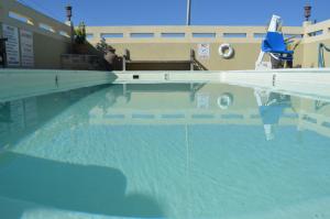 a swimming pool with a reflection of a chair in the water at Hill Country Inn in Marble Falls