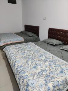 two beds sitting next to each other in a room at Rawat Homestay in Gupta Kāshi
