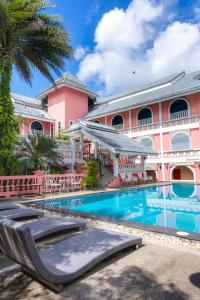 a resort with a swimming pool and a pink building at Rasa Boutique Hotel Chiang Rai in Chiang Rai