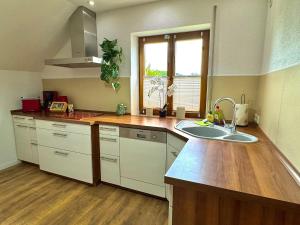 a kitchen with white cabinets and a sink and a window at Savor Appartement Bergblick für 6 Personen in Sohland