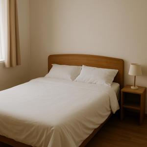 a bed with white sheets and pillows next to a window at Casa fb in Sao Paulo