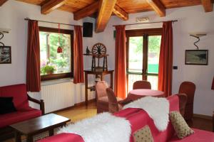 a living room with a red couch and a table at Hotel Banchetta in Sestriere