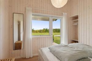 Bogø ByにあるSpacious Holiday Home On Bogøのベッドと大きな窓のある寝室