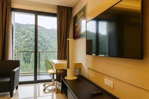 a hotel room with a desk and a large window at Grand Ion Delemen Premium Room by TOPHOME in Genting Highlands