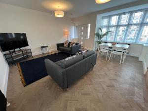Parkestonにある2 Royal Apartments, Ground Floor,two Bed,Fast Wifiのソファ、テレビ、テーブルのあるリビングルーム
