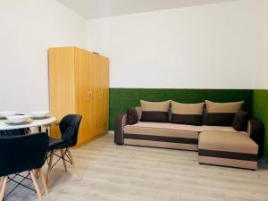 Una sala de estar con una cama, una mesa y sillas. en The Union Square Apartament, en Oradea