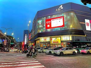 a busy city street with cars parked in front of a building at 哲帆名宿 西永微电园龙湖高新天街Loft智能店 in Tuzhu