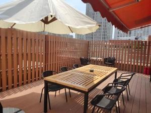 a wooden table and chairs with an umbrella on a deck at Atour Hotel Jinan Tangyan Century Avenue in Jinan