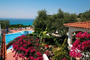 uma vista para uma piscina com flores cor-de-rosa em Residence Villaggio Smedile em Capo Vaticano