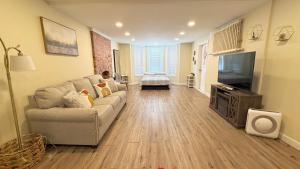 a living room with a couch and a flat screen tv at Classical Isbills Row House close to NYC in Bayonne