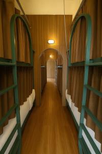 Un pasillo vacío de un tren con estantes verdes. en กรุงไทย โฮสเทล สเตชั่น, en Thonhuri
